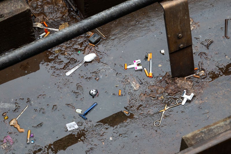 Used needles litter the ground