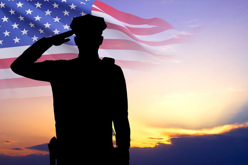 Silhouette of police man with USA flag against the sunset 