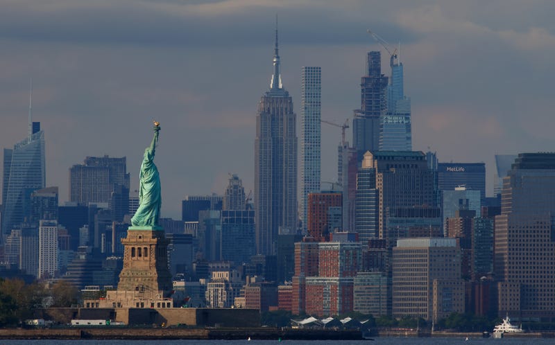 The sun sets over the Statue of Liberty and the Manhattan skyline on May 12, 2024, as seen from Bayonne, New Jersey