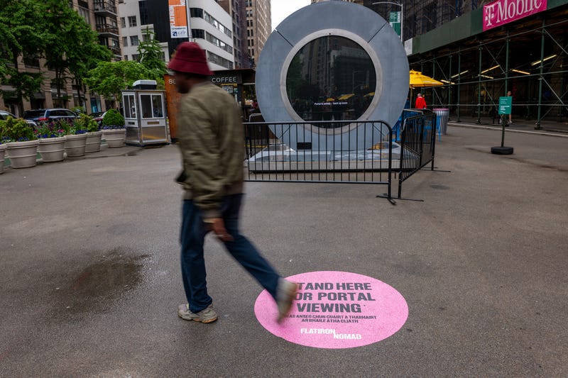 People pass a video "Portal" art installation connecting New York City and Dublin on May 15, 2024