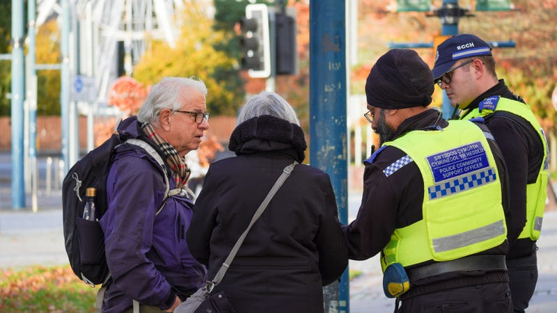 Two senior citizens talking to police officers outdoors