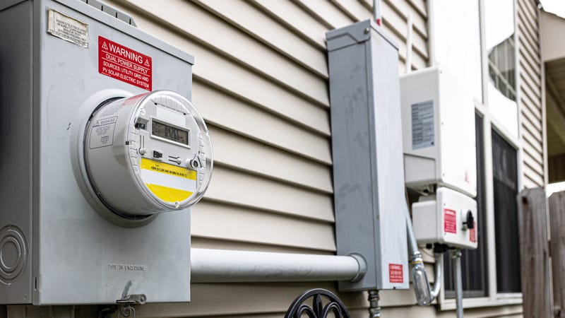 Electricity meter and cables along the side of a house