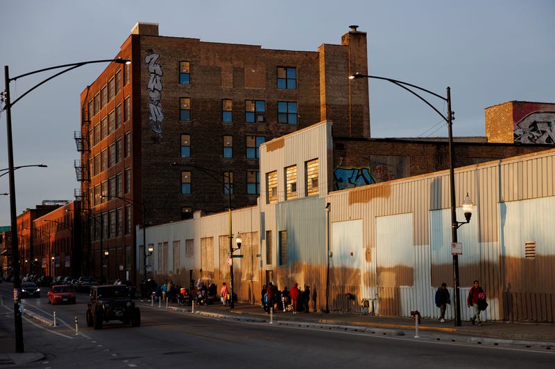 People walk outside a migrant shelter on the Lower West Side on March 11, 2024, in Chicago.