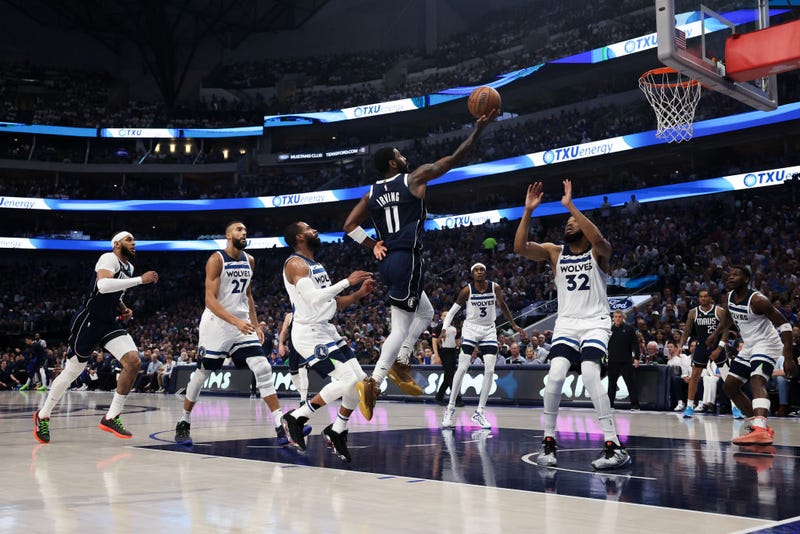 Kyrie Irving #11 of the Dallas Mavericks shoots the ball between Mike Conley #10 and Karl-Anthony Towns #32 of the Minnesota Timberwolves during the second quarter in Game Three of the Western Conference Finals.