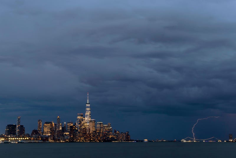 Lightning strikes behind the Verrazzano-Narrows Bridge as a thunderstorm passes by lower Manhattan and One World Trade Center in New York City on May 29, 2024, as seen from Hoboken, New Jersey