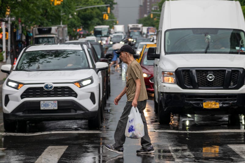 Pedestrians and cars move through Midtown Manhattan traffic on June 6, 2024