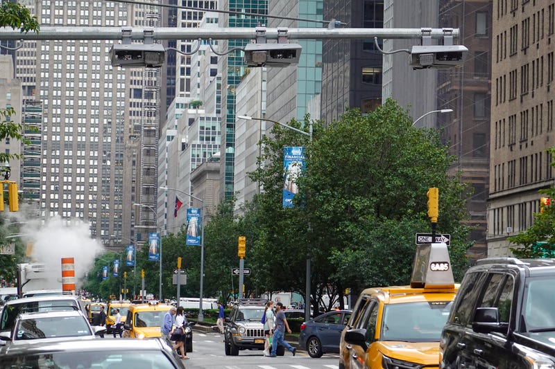 Vehicles drive under the congestion pricing facilities on June 11, 2024