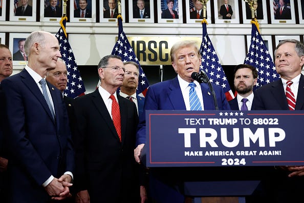 Republican presidential candidate, former U.S. President Donald Trump, is flanked by Senate Republicans as he gives remarks to the press at the National Republican Senatorial Committee building on June 13, 2024 in Washington, DC.