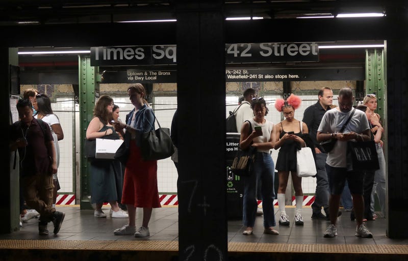 People wait to board a train at the Times Square - 42nd Street subway station on June 13, 2024