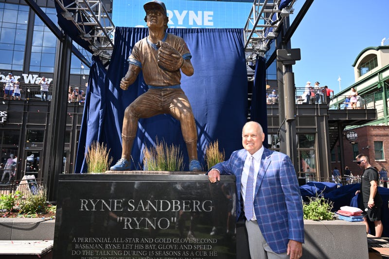 Former Chicago Cubs player and Hall of Famer Ryne Sandberg poses for pictures in front of his statue before a game against the New York Mets at Wrigley Field on June 23, 2024, in Chicago