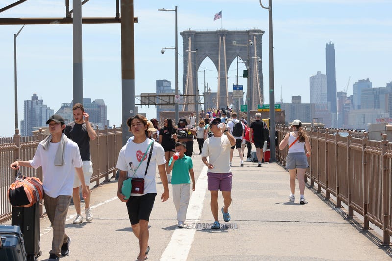 People walk along the Brooklyn Bridge amid a heat wave on June 20, 2024