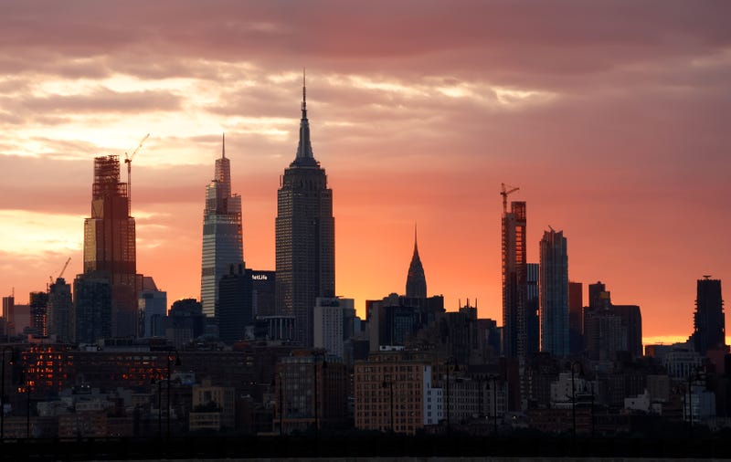 The sun rises behind the Empire State Building and Chrysler Building in New York City on June 24, 2024