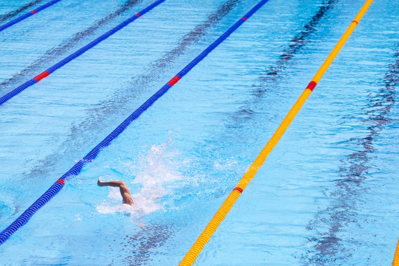 Swimmer swimming freestyle stroke or front crawl during sport swim meet in an Olympic-size swimming pool
