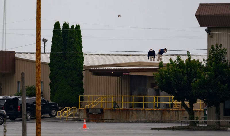 Two FBI investigators scan the roof of AGR International Inc, the building adjacent to the Butler Fairgrounds, from which alleged shooter Matthew Thomas Crooks fired at former President Donald J. Trump