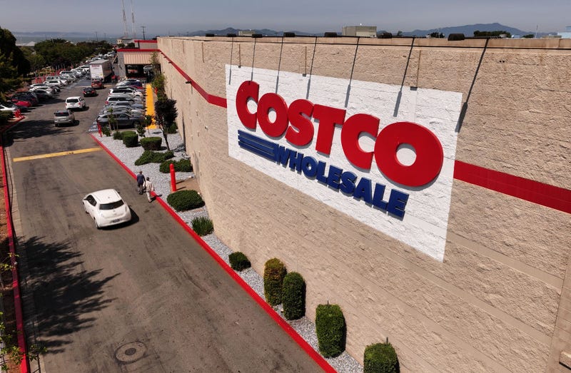 n an aerial view, the Costco logo is displayed on the exterior of a Costco store 