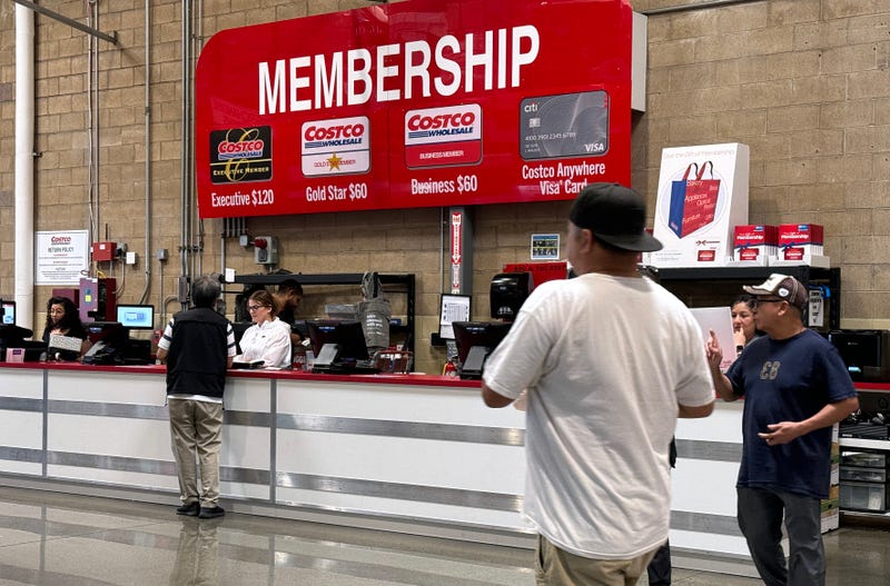 Customers walk by the membership counter at a Costco store. Costco announced plans to raise membership fees for the first time since 2017 with a $5 jump to $65 a year from $60.