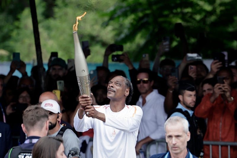Snoop Dogg holds the torch as part of the 2024 Paris Olympic Games Torch Relay, in Saint-Denis on July 26, 2024 in Paris, France.