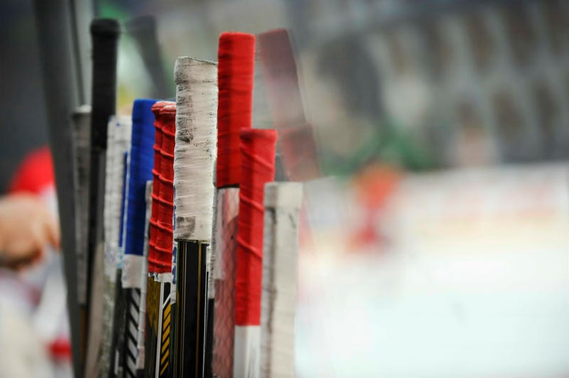 Stack of hockey sticks at a rink, showing the grip tape at the top
