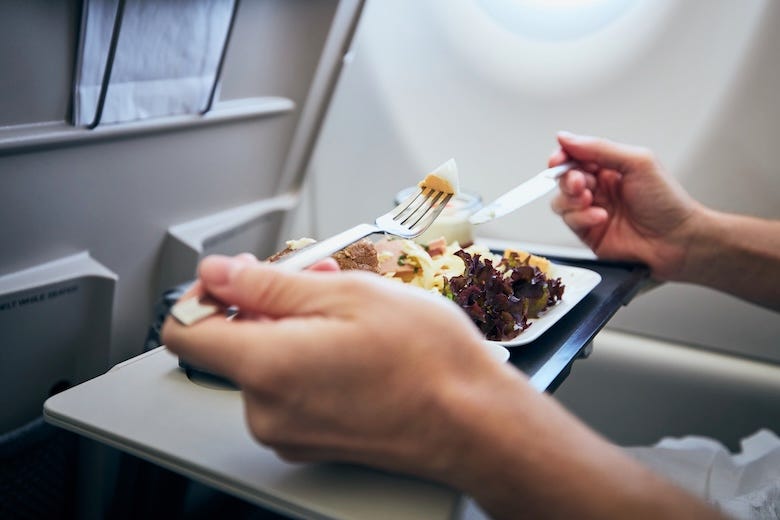 Woman eating an in-flight meal on an airplane