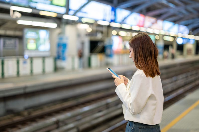 Person on phone at metro station 