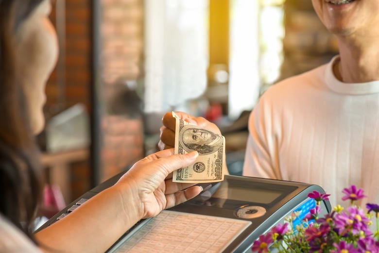 Woman paying with cash at a store