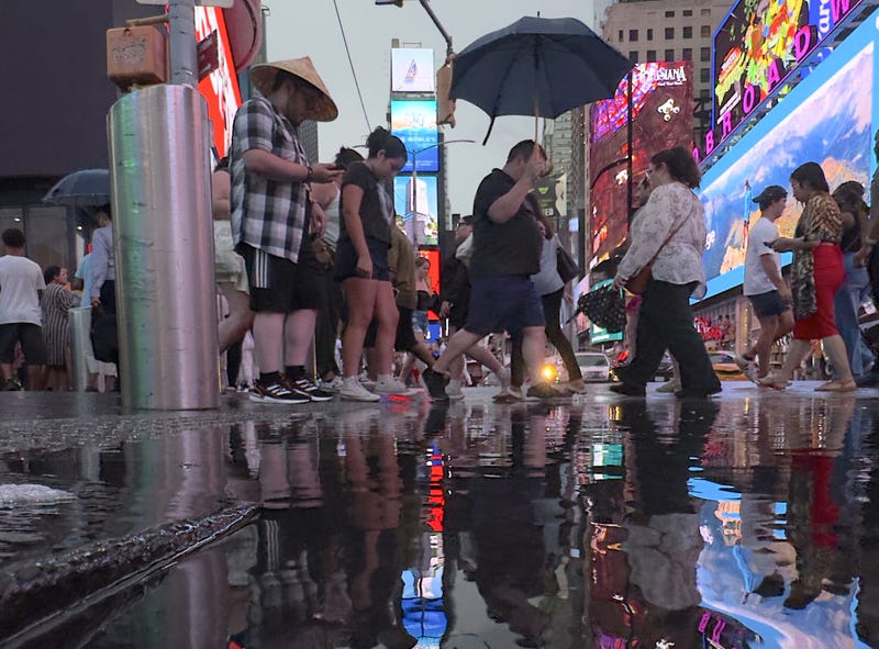 People are seen in Times Square during a rain storm in New York City, United States on August 2, 2024.