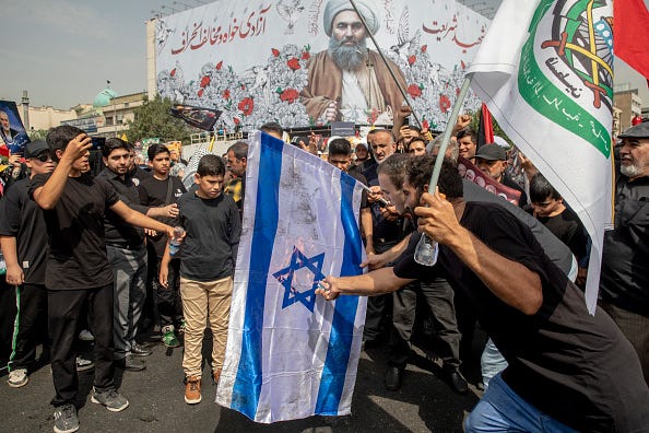 Iranians burn a representation of the Israeli flag during the funeral ceremony of Hamas leader Ismail Haniyeh and his bodyguard who were killed in an assassination blamed on Israel on Wednesday, at Enqelab-e-Eslami (Islamic Revolution) Sq. on August 1, 2024 in Tehran, Iran. 