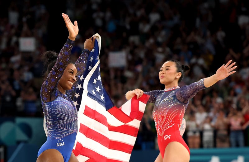 Gold medalist Simone Biles (L) and Bronze medalist Sunisa Lee of Team United States celebrate with the American flag after competing in the Artistic Gymnastics Women's All-Around Final on day six of the Olympic Games Paris 2024 at Bercy Arena on August 01, 2024 in Paris, France.