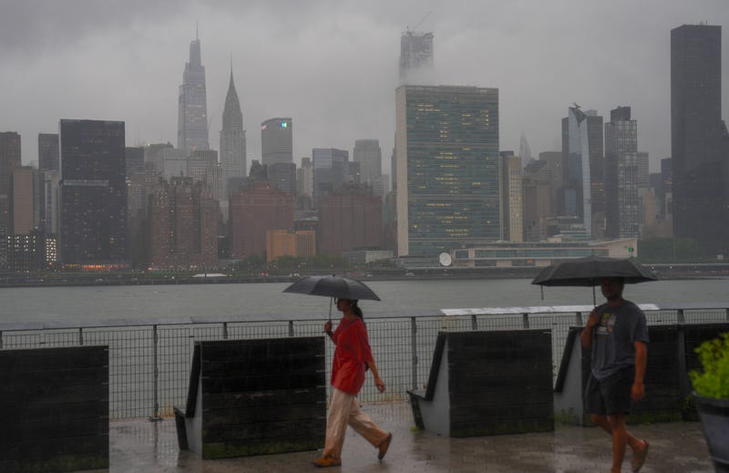 People walk in Long Island City on a rainy Wednesday morning. Tuesday night's storm dropped more than 5 inches of rain some parts of the Tri-State