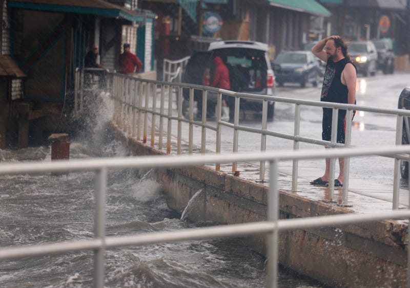 person stands in the rain and wind