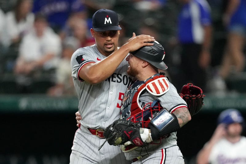 Jhoan Duran #59 and Christian Vázquez #8 of the Minnesota Twins celebrate after defeating the Texas Rangers at Globe Life Field on August 15, 2024 in Arlington, Texas.