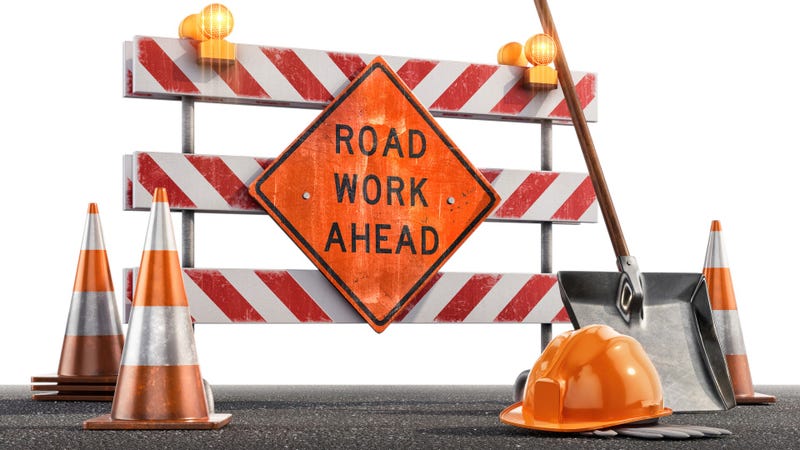 Сonstruction site with a Road Work Ahead sign, traffic cones, hard hat, shovel against a white background. - stock photo