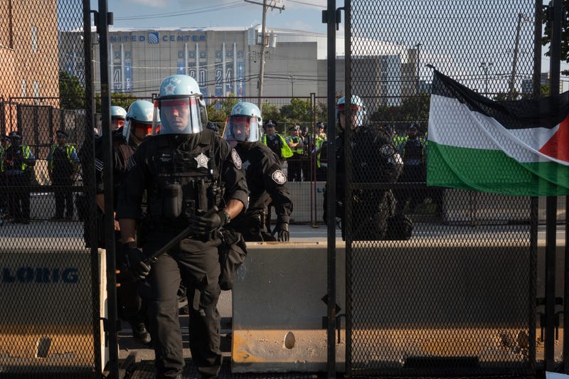 Police in riot gear enter Park 578 near the United Center through a damaged security fence panel was breached by protestors in the park on Aug. 19, 2024. The security perimeter surrounds the Democratic National Convention.
