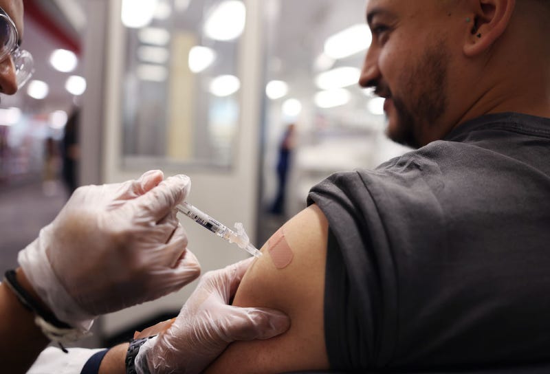 A man receives a vaccination against flu and COVID-19 at a CVS.