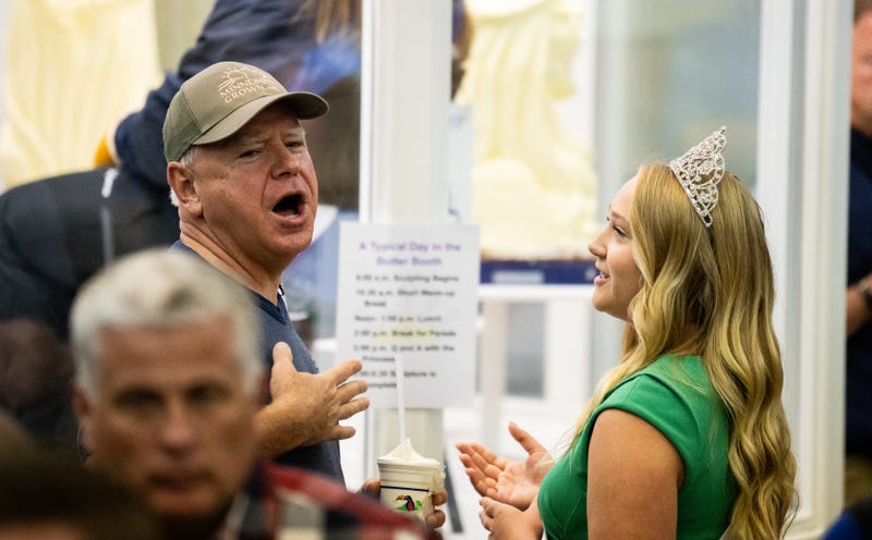 Democratic vice presidential nominee Minnesota Gov. Tim Walz speaks with Rachel Visser, the 71st Princess Kay of the Milky Way, as they look at the butter sculptures in the Dairy Barn in the Minnesota State Fair on September 1, 2024 in Falcon Heights, Minnesota.  