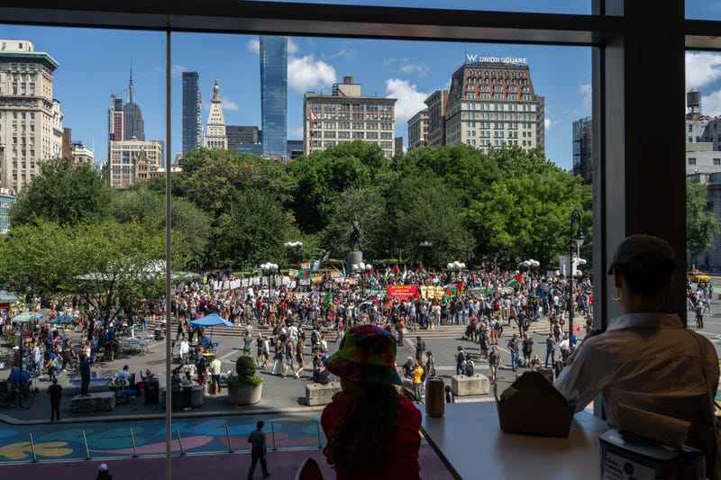 People watch from a window as people attend a protest on Labor Day in Union Square on Sept. 2, 2024 in New York City. Following the deaths of six hostages in Gaza, protestors demand that Israel reach a deal with Hamas.