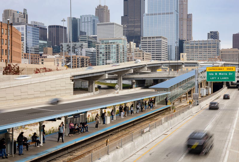 Passengers wait for a CTA Blue Line train at Halsted/UIC as traffic passes on the Eisenhower Expressway and the Jane Byrne Circle Interchange in front of the skyline on Oct. 24, 2022.