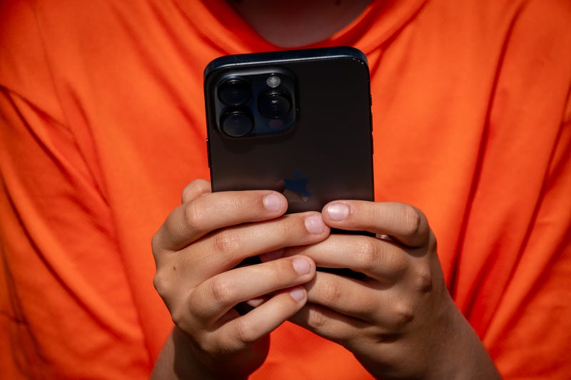 A 12-year-old boy looks at a iPhone screen