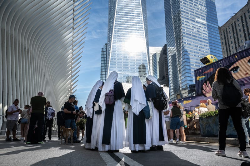 A group of nuns pray outside of the perimeter of the 9/11 memorial site during a moment of silence on September 11, 2024 in New York City
