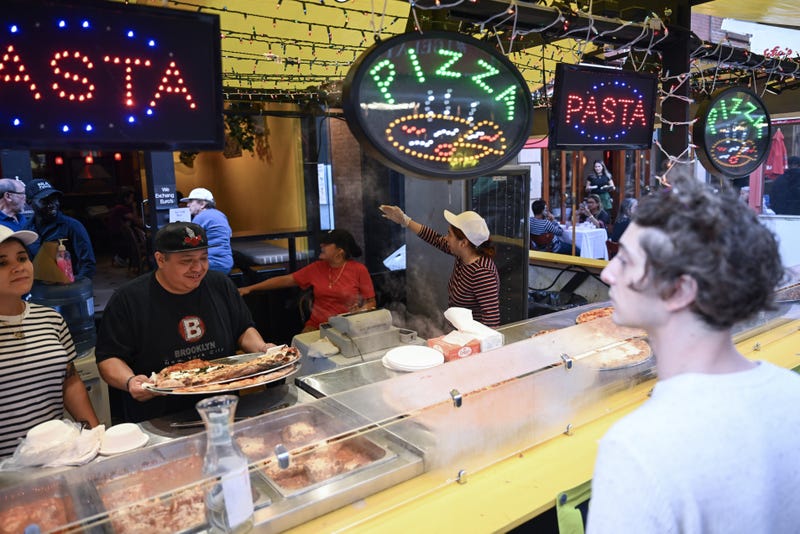 Vendors serve a customer at the street fair on Sept. 12, 2024