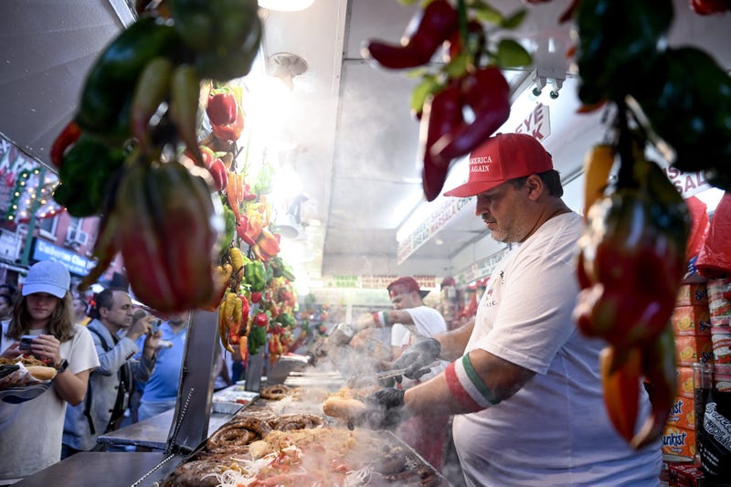A vendor prepares an Italian sausage sandwich at the festival