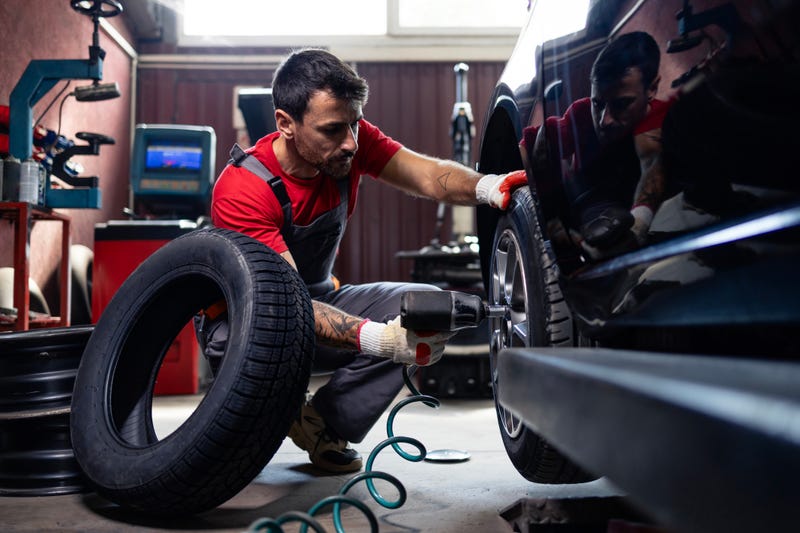 Mechanic changes a tire in an auto repair shop