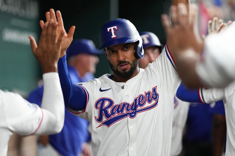 Marcus Semien #2 of the Texas Rangers is congratulated in his dugout after scoring a run during the fourth inning against the Toronto Blue Jays at Globe Life Field on Sept. 17, 2024 in Arlington, Texas.