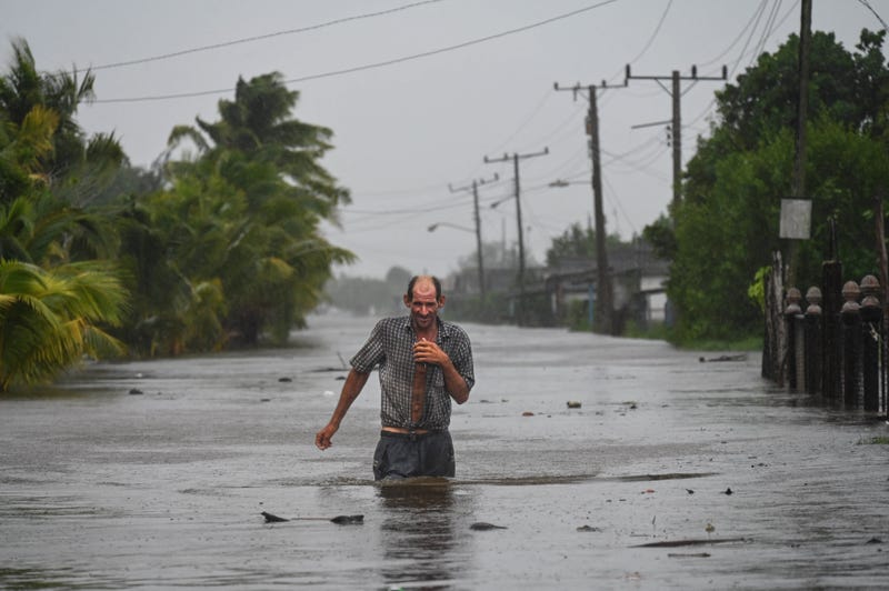 A resident of the Cuban coastal town of Guanimar, located southwest of Havana, wades trough a flooded street after the passage of Hurricane Helene on Sept. 25, 2024.