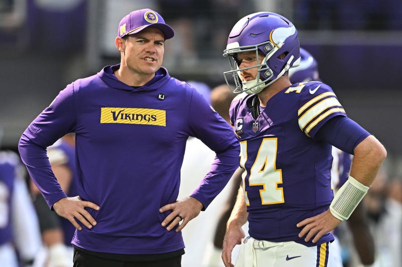 Kevin O'Connell, head coach of the Minnesota Vikings, speaks to quarterback Sam Darnold #14 before the game against the Houston Texans at U.S. Bank Stadium on September 22, 2024 in Minneapolis, Minnesota. 
