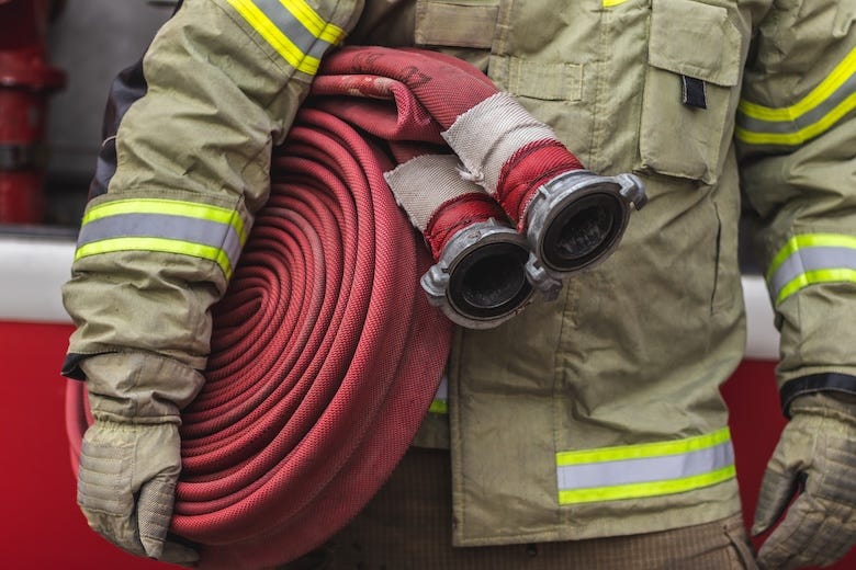 Firefighter carrying a hose