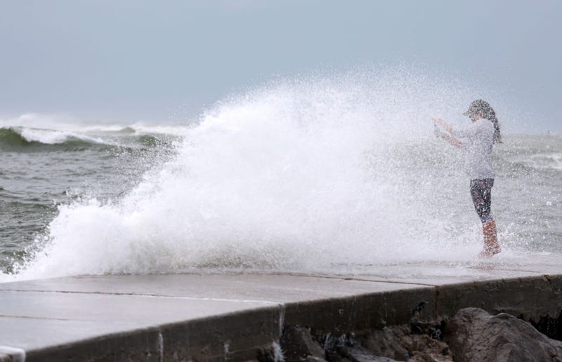 Valerie Barrington gets caught in a wave crashing ashore from the Gulf of Mexico as Hurricane Helene passes offshore on September 26, 2024 in St. Pete Beach, Florida.