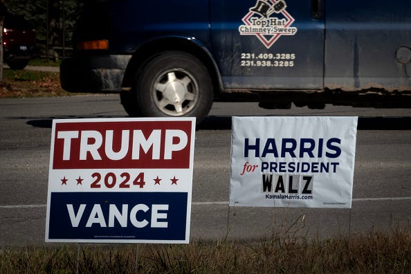 Signs showing support for both Democratic presidential candidate Vice President Kamala Harris and Republican presidential candidate former President Donald Trump sit along a rural highway on September 26, 2024 near Traverse City, Michigan.