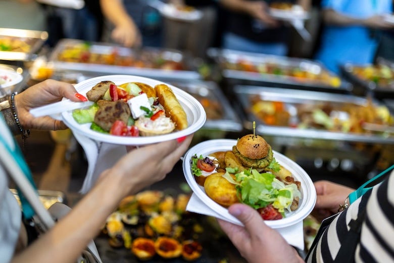 Women holding plates of food during a festival