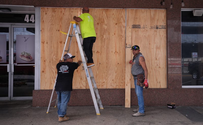 Workers board up a business